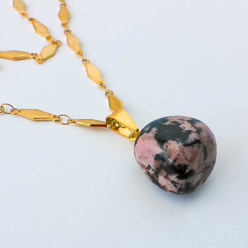Material: Piedra natural de Rodonita y cadena de acero inoxidable chapado oro .Longitud collar: 50 cm. ,dimensión piedra: 2x1,5 cm.Propiedades de la piedra:Piedra calmante que reduce la ansiedad, indicada contra miedos excesivos y angustia. Para superar momentos difíciles y traumas. Alivia confusión, elimna somatizaciones, cura shoks emocionales, calma y reconforta. Curación de vidas pasadas y de emociones dificiles, limpia y cicatriza las heridas emocionales.Elemento agua: Emociones, deseos, curación, liberación, fluidez, avance.*Las piedras semipreciosas pueden variar ligeramente de tono y forma debido a su origen natural*