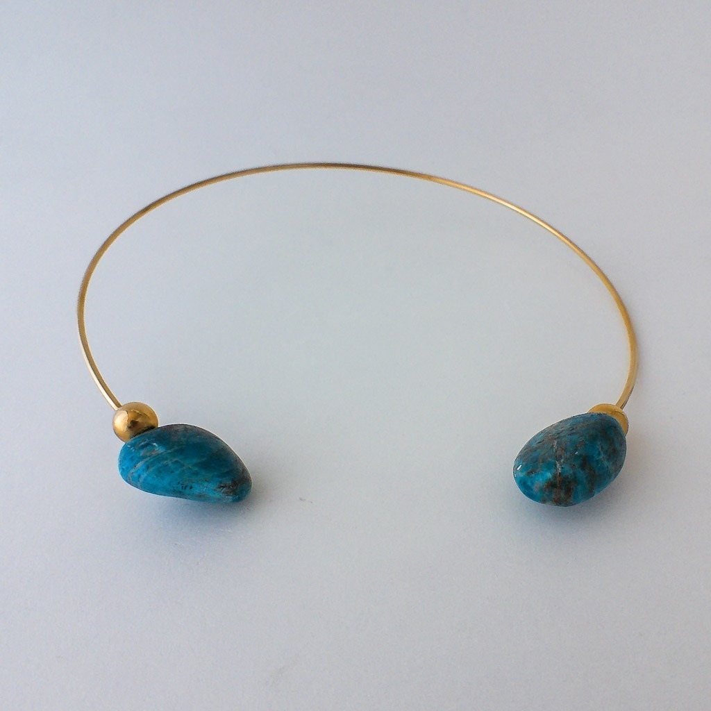 Material: Piedras naturales de Apatitas con choker rígido de acero inoxidable bañado en oro. Diámetro del collar: 45 cm.Dimensión de las piedras: 2,5 x2 cm .Propiedades de la piedra: Propiedad de inspirar y fomentar la intuición y la creatividad. Da confianza y calma. Retira la negatividad. Expande el conocimiento y aumenta los dones psíquicos y la intuición. Retira la negatividad y fomenta la concentración y la motivación. Conecta con guías espirituales.Elemento aire: espiritualidad, pensamiento, pureza, libertad, renovación.*Las piedras semipreciosas pueden variar ligeramente de tono y forma debido a su origen natural*.