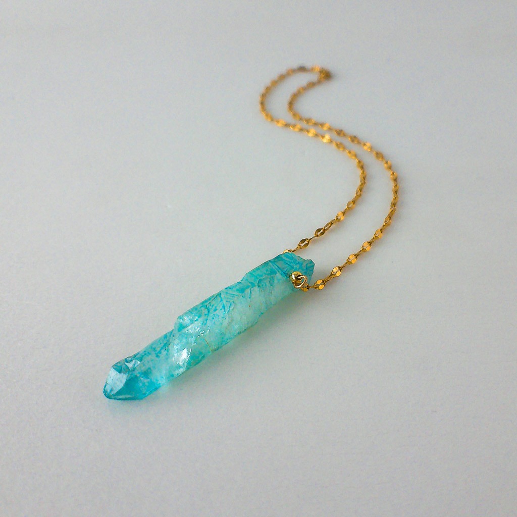 Material: Punta natural de piedra Aqua Aura y cadena acero inoxidable. Longitud collar: 40 cm. Dimensión piedra: 5 x 1 cm. Propiedades de la piedra: Vibración calmante muy fuerte, protección contra ataques psíquicos, expulsa estrés y negatividad. Proporciona un gran bienestar y paz, es un antidepresivo natural. Fomenta la conciencia cósmica y el desarrollo personal. Induce a la visión psíquica y la telepatía. Protección y limpieza del alma. Elemento: Aire. Espiritualidad, pensamiento, pureza, libertad, renovación. *Las piedras semipreciosas pueden variar ligeramente de tono y forma debido a su origen natural*