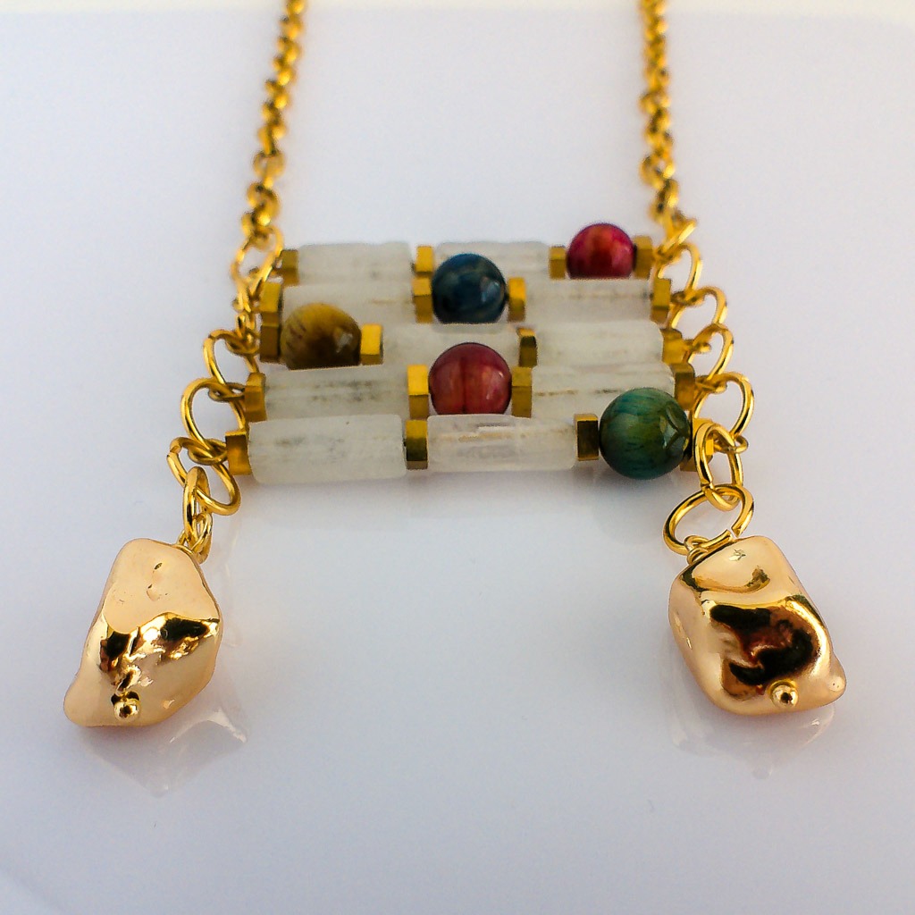 Material: Piedra natural de Jade Blanco en rectángulos, cuentas naturales redondas Ojo de Gato de colores y cadena y fornituras de acero inoxidable bañadas en oro. Longitud collar: 80 cm. Propiedades de las piedras: Poder y suerte del Jade blanco unido a la protección del Ojo de Gato. *Las piedras semipreciosas pueden variar ligeramente de tono y forma debido a su origen natural*