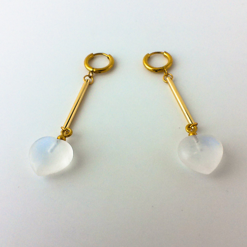 Material: Pendientes de aro con barra de acero inoxidable y corazón de Piedra Luna. Longitud : 6 cm. Propiedades de la piedra: Aporta paz y sabiduría, despertar espiritual, protección. Calma emociones, estimula la percepción y clarividencia. Aporta seguridad y consuelo. Es un guía espiritual, hace consciente lo inconsciente. Favorece los cambios y las sincronías. Estimula creatividad y la sensibilidad. Elemento Aire: Espiritualidad, pensamiento, pureza, libertad, renovación. *Las piedras semipreciosas pueden variar ligeramente de tono y forma debido a su origen natural*