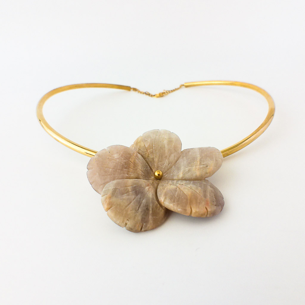 Material: Choker rígido de acero inoxidable bañado en oro con flor de Piedra Luna. Tamaño de la piedra: 6 cm. Diámetro del collar: 15 cm. Propiedades de la piedra: Aporta paz y sabiduría, despertar espiritual, protección, calma emociones, estimula la percepción y clarividencia. Aporta seguridad y consuelo. Es un guía espiritual, hace consciente lo inconsciente. Favorece los cambios y las sincronías. Estimula creatividad y la sensibilidad.Elemento Aire: Espiritualidad, pensamiento, pureza, libertad, renovación. *Las piedras semipreciosas pueden variar ligeramente de tono y forma debido a su origen natural*