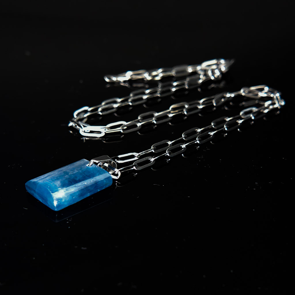 Material: Piedra rectangular de Cianita con cadena de acero inoxidable. Tamaño de la piedra: 15 x 11 mm. Largo: 26,5 cm. Propiedades de la piedra: Piedra tranquilizante que fomenta la calma, la meditación y la energía espiritual. Calma el miedo y la ansiedad. Aporta intuición, inspiración y creatividad. Equilibra y purifica. Estimula la mente superior conectándola con frecuencias elevadas. Ayuda a encontrar soluciones. Facilita el proceso espiritual atrayendo la luz al campo físico. Elemento: Aire. Espiritualidad, pensamiento, pureza, libertad, renovación. *Las piedras semipreciosas pueden variar ligeramente de tono y forma debido a su origen natural*